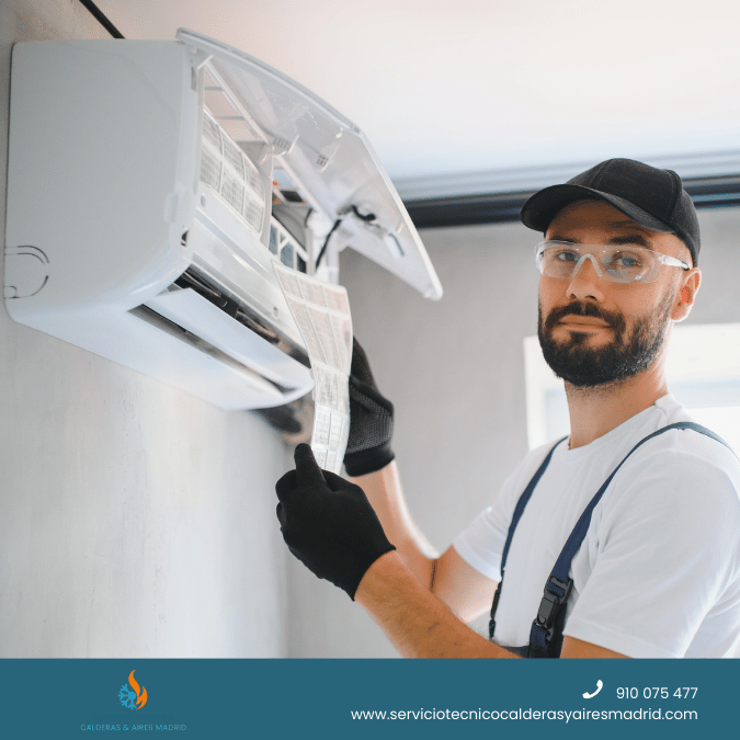 Técnico realizando servicio técnico de aire acondicionado en Madrid mientras limpia los filtros del equipo